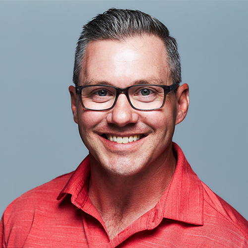 Ron Martiello, Math Education Consultant and author of Conquering Math Myths, smiling in a red shirt.