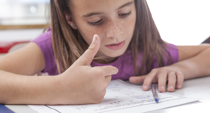 Picture of a young, female student working on a math problem. 